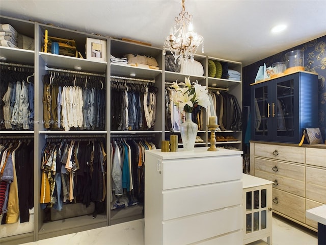 walk in closet featuring a chandelier