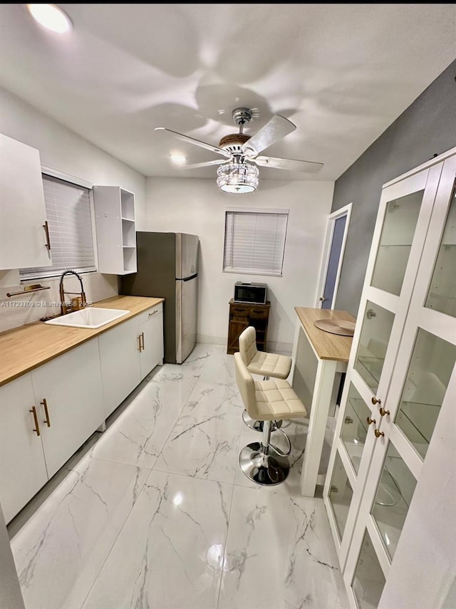 kitchen with sink, stainless steel fridge, and ceiling fan