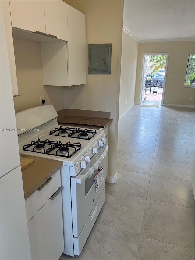 kitchen featuring white range with gas stovetop, electric panel, white cabinets, and ornamental molding