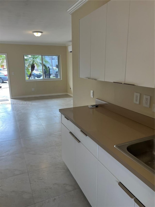 kitchen featuring sink, white cabinets, and ornamental molding