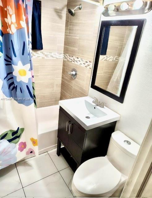 bathroom with toilet, vanity, and tile patterned flooring