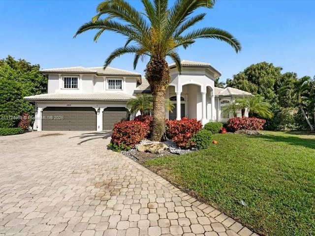 mediterranean / spanish-style house with a garage and a front lawn