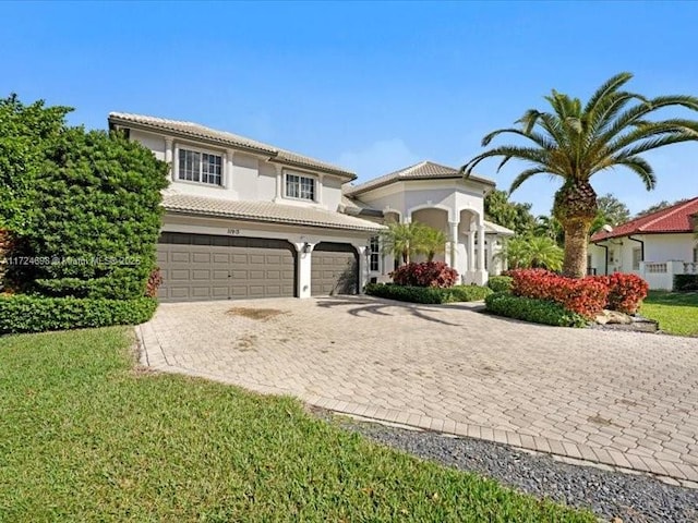 mediterranean / spanish-style house with a front lawn and a garage