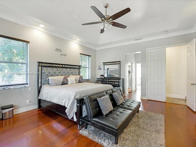 bedroom with ceiling fan, dark hardwood / wood-style flooring, and a raised ceiling