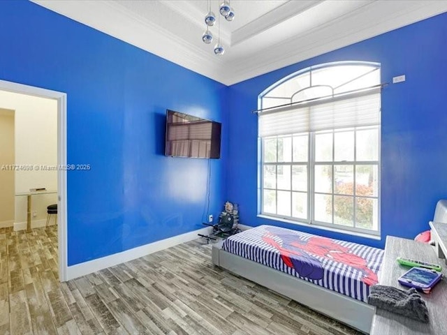 unfurnished bedroom with wood-type flooring, a tray ceiling, and ornamental molding