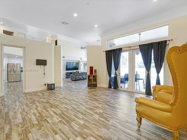 living area with french doors, ornamental molding, and light hardwood / wood-style flooring