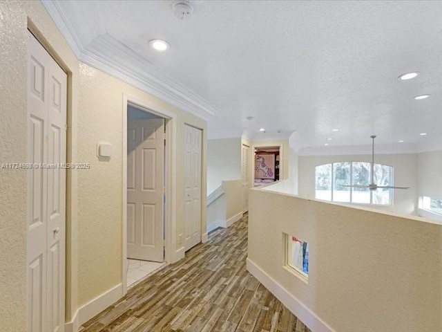 hallway with ornamental molding and hardwood / wood-style floors