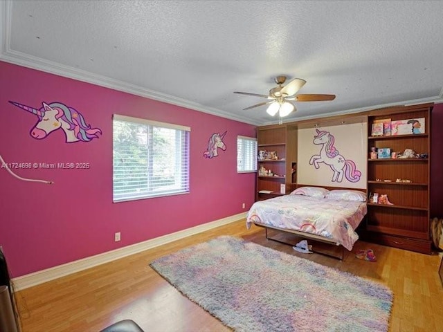 bedroom featuring a textured ceiling, ceiling fan, ornamental molding, and wood-type flooring