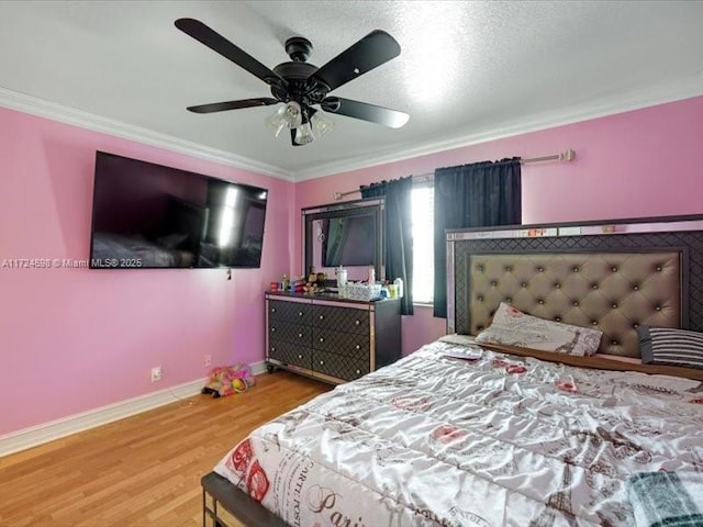 bedroom with ceiling fan, ornamental molding, and wood-type flooring