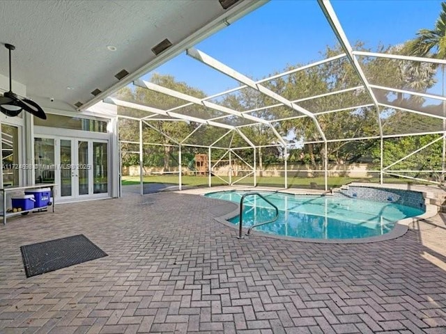 view of swimming pool with a lanai, a patio area, and french doors