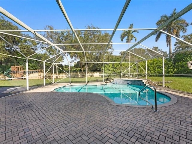 view of swimming pool with glass enclosure and a patio area