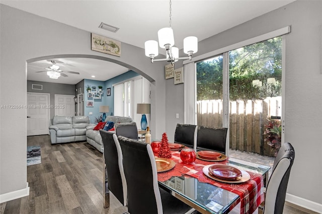 dining room with hardwood / wood-style floors and ceiling fan with notable chandelier