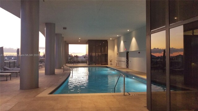 pool at dusk with a patio