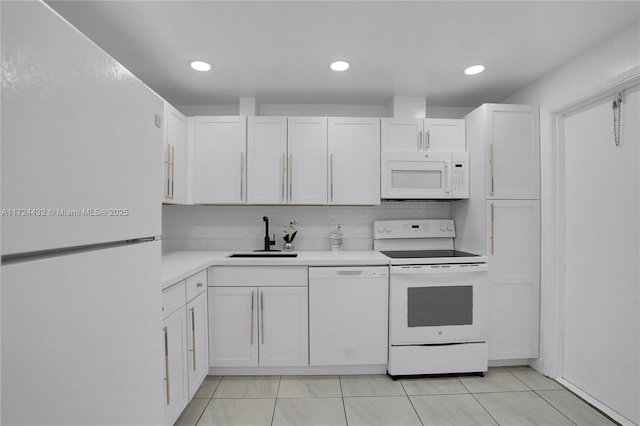 kitchen with white appliances, light tile patterned floors, decorative backsplash, white cabinets, and sink