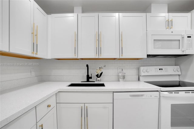 kitchen with white appliances, white cabinets, backsplash, and sink