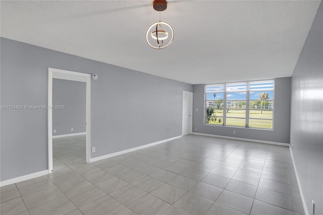 empty room featuring light tile patterned flooring and a chandelier