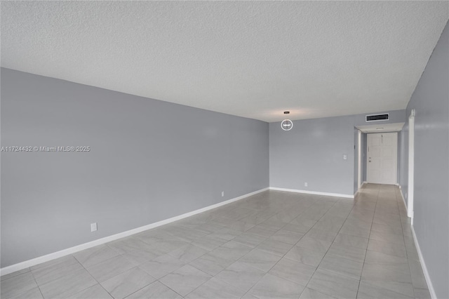 empty room featuring light tile patterned flooring and a textured ceiling