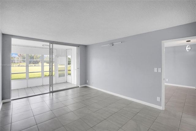 unfurnished room with tile patterned flooring and a textured ceiling