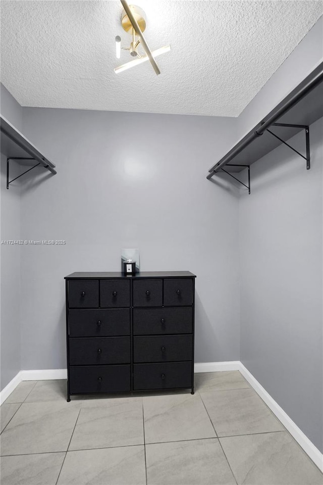 spacious closet with light tile patterned floors