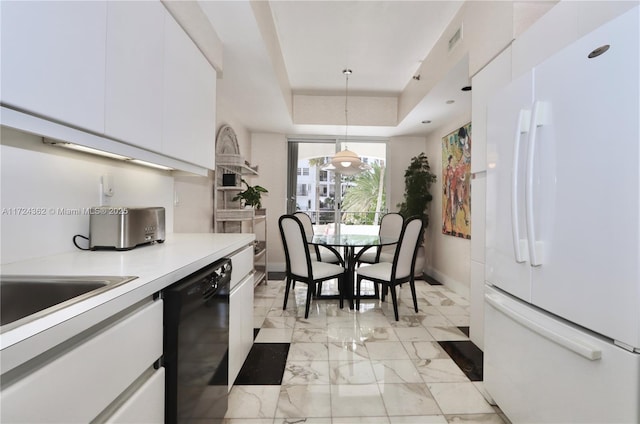 kitchen featuring white fridge, a raised ceiling, white cabinetry, and hanging light fixtures