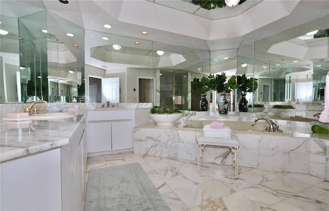 bathroom featuring a raised ceiling, a tub, and vanity