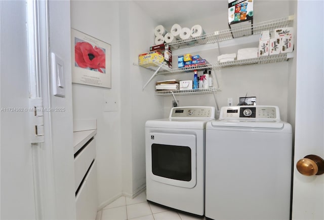 clothes washing area featuring light tile patterned flooring and separate washer and dryer