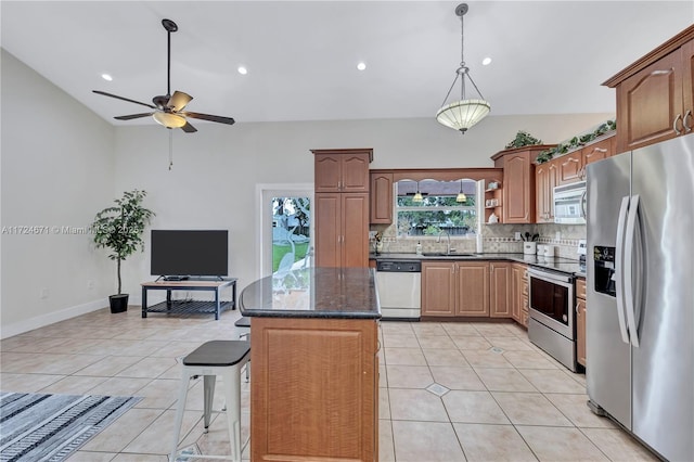 kitchen featuring light tile patterned floors, sink, appliances with stainless steel finishes, a kitchen breakfast bar, and decorative backsplash