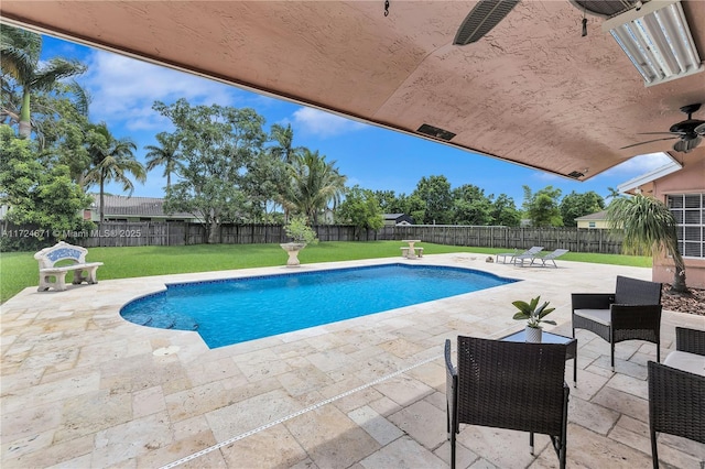 view of swimming pool with a yard, a patio area, and ceiling fan