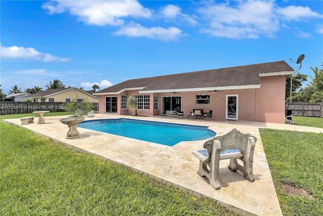 view of swimming pool featuring a patio area, ceiling fan, and a lawn