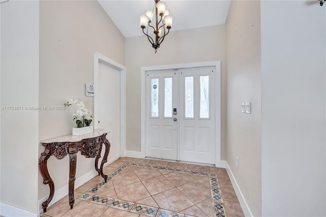 tiled foyer with a chandelier