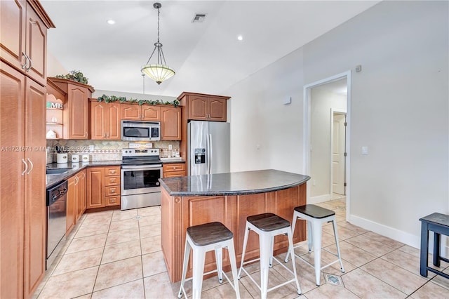 kitchen featuring stainless steel appliances, a center island, light tile patterned floors, and decorative backsplash