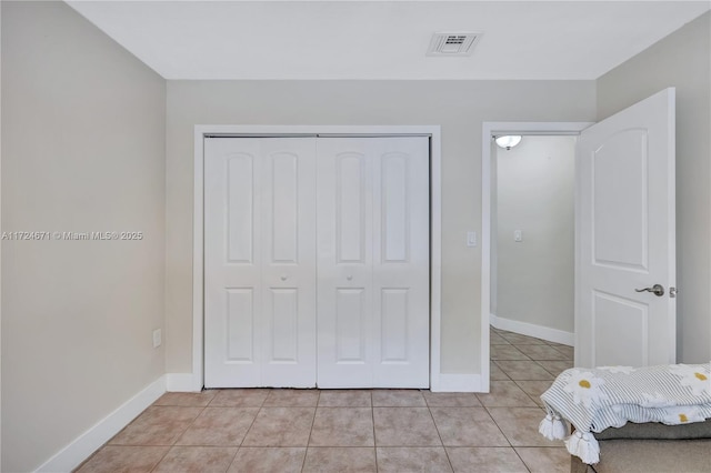 unfurnished bedroom with a closet and light tile patterned flooring