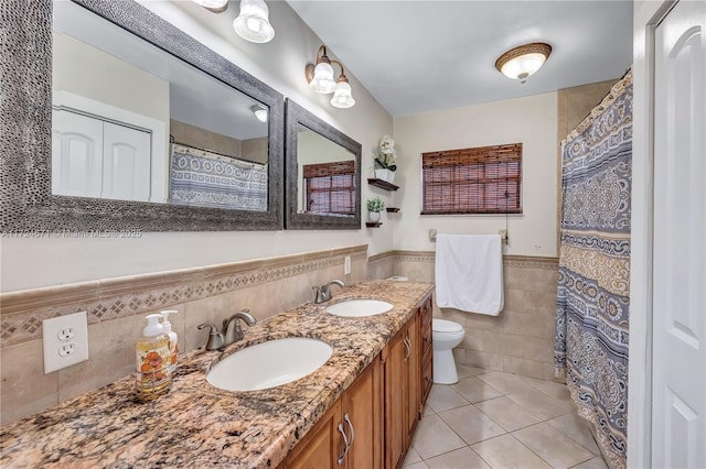 bathroom with tile walls, vanity, tile patterned floors, and toilet