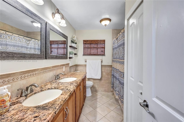 bathroom with tile patterned flooring, vanity, tile walls, and toilet