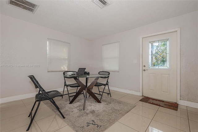 dining area with light tile patterned floors and a textured ceiling