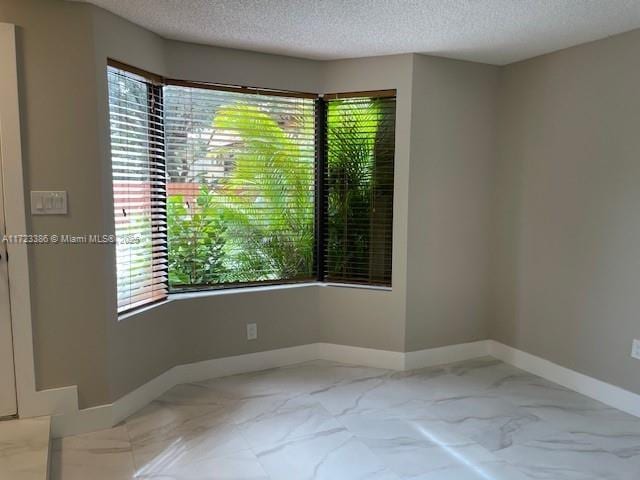 spare room with a textured ceiling