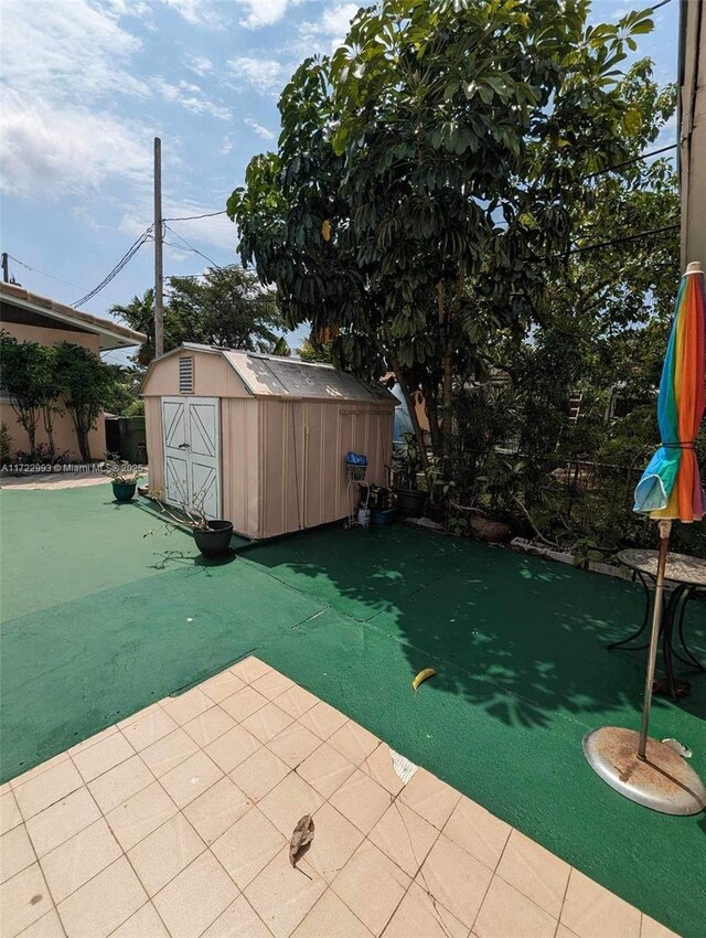 view of pool featuring a shed and a patio