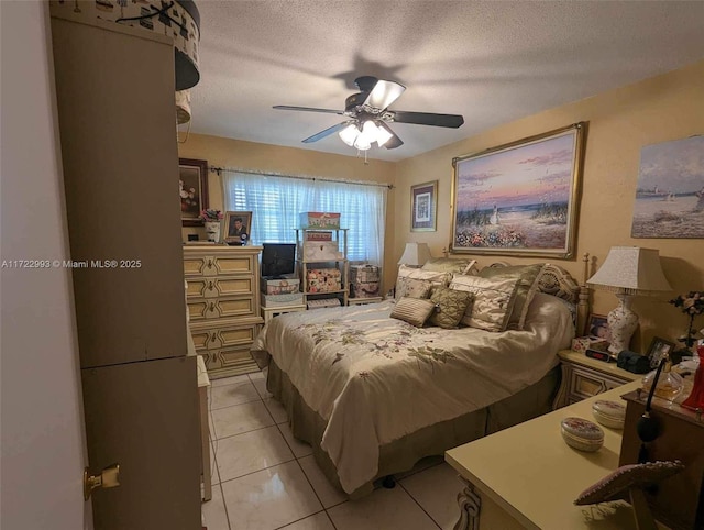 bedroom with ceiling fan, light tile patterned floors, and a textured ceiling