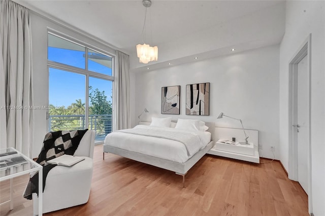 bedroom with hardwood / wood-style floors and a notable chandelier