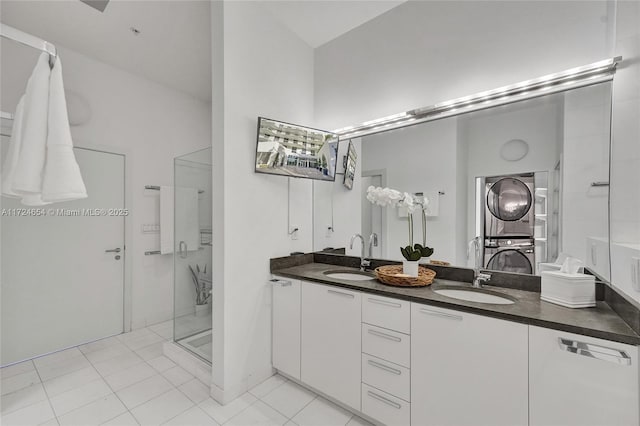 bathroom featuring tile patterned floors, vanity, a shower with shower door, and stacked washer and dryer