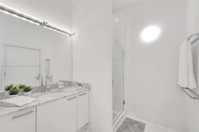 bathroom with tile patterned flooring, vanity, and walk in shower