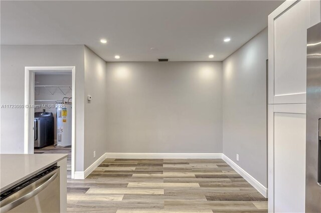 interior space featuring washer / dryer, water heater, and light wood-type flooring