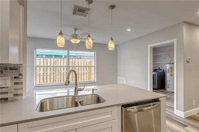 kitchen featuring electric water heater, dishwasher, sink, hanging light fixtures, and white cabinets