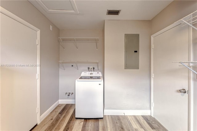 laundry area featuring washer / dryer, electric panel, and light hardwood / wood-style flooring