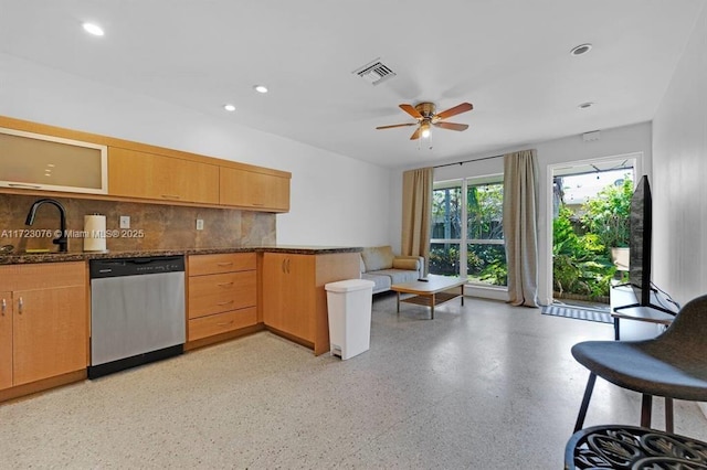 kitchen featuring ceiling fan, backsplash, dishwasher, sink, and dark stone counters