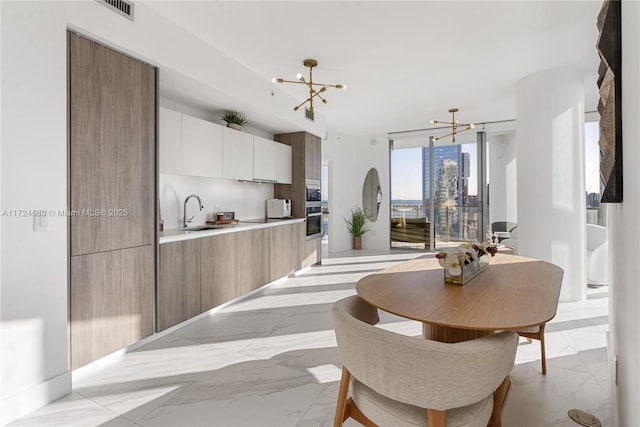 dining area featuring expansive windows and a chandelier