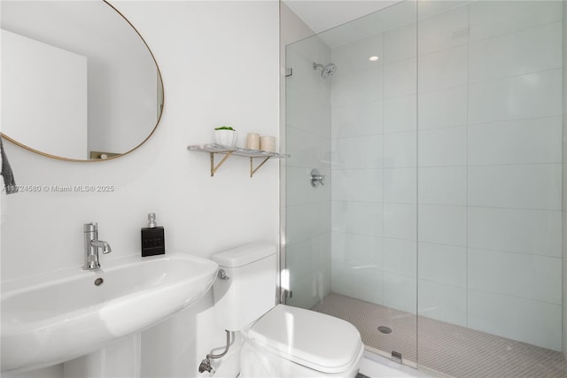 bathroom featuring toilet, an enclosed shower, and sink