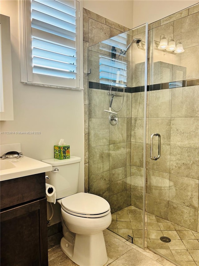 bathroom featuring vanity, toilet, and an enclosed shower