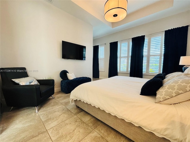 bedroom featuring a raised ceiling and tile patterned floors