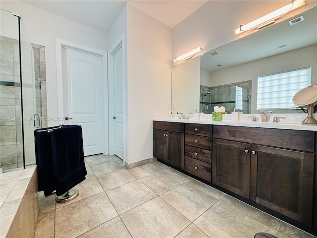 bathroom with tile patterned flooring, vanity, and walk in shower